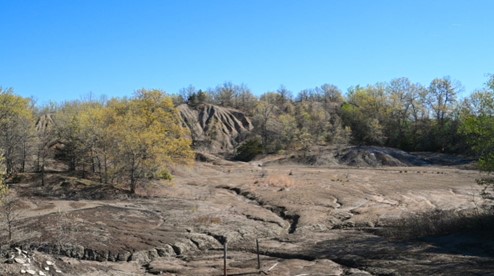 Spoil piles loom like mountains over the Kuiper AML site in Marion County, Iowa, May 2, 2023. These lumps of barren earth were piled up during the mining process and left as waste. (Photo by Emily Isaac, OSMRE AmeriCorps fellow)