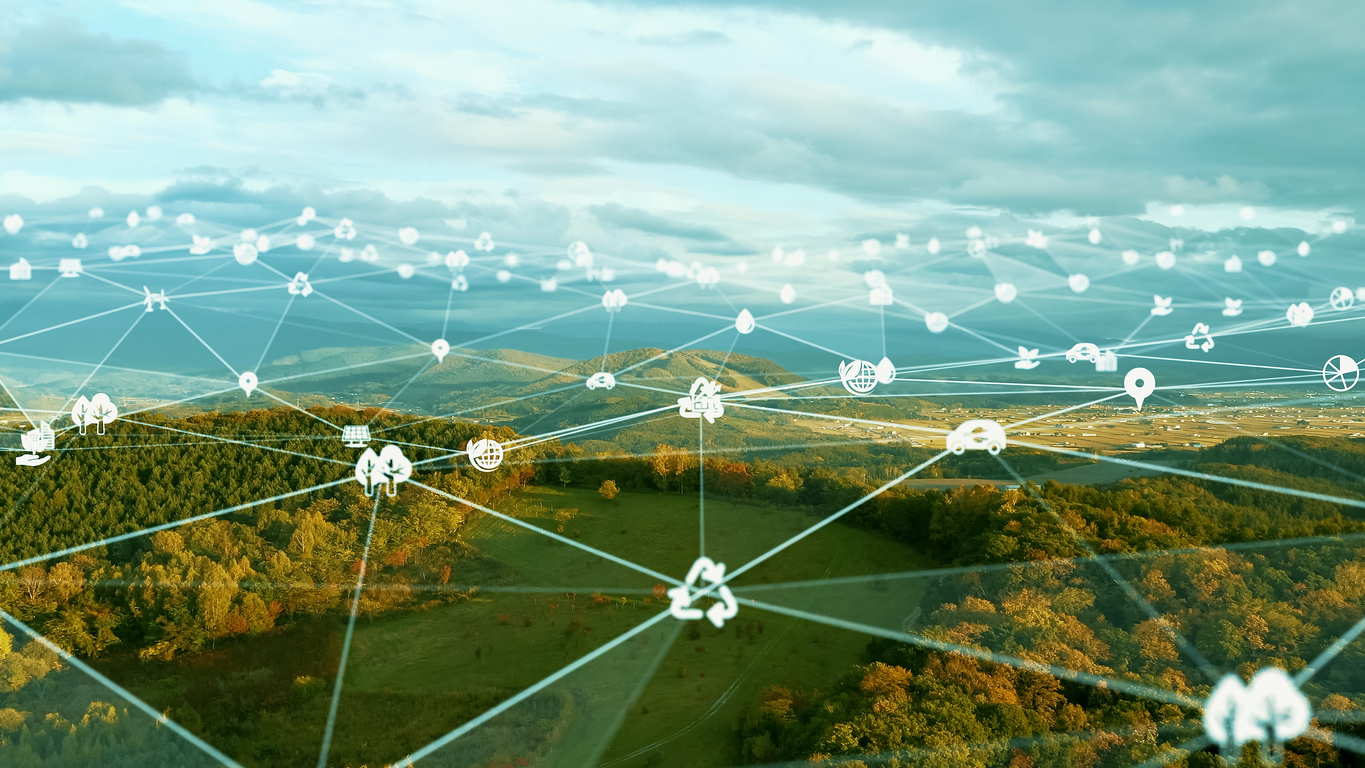 A landscape scene of fields and trees has a grid of sustainability logos overlaid