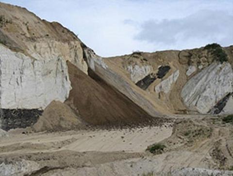Steep and jagged, tan-colored highwalls jut out of an abandoned mine area near Healy Creek, AK