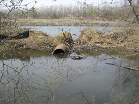 Two ponds are surrounded by trees with an old pipe in between, representing part of an abandoned mine